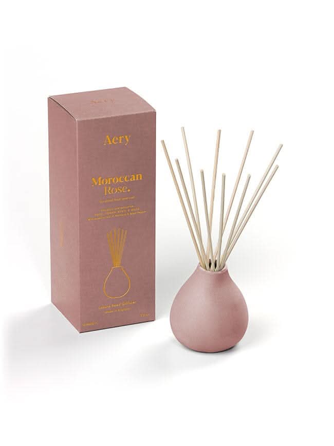 Aubergine Moroccan Rose candle by Aery displayed next to product packaging on white bacground
