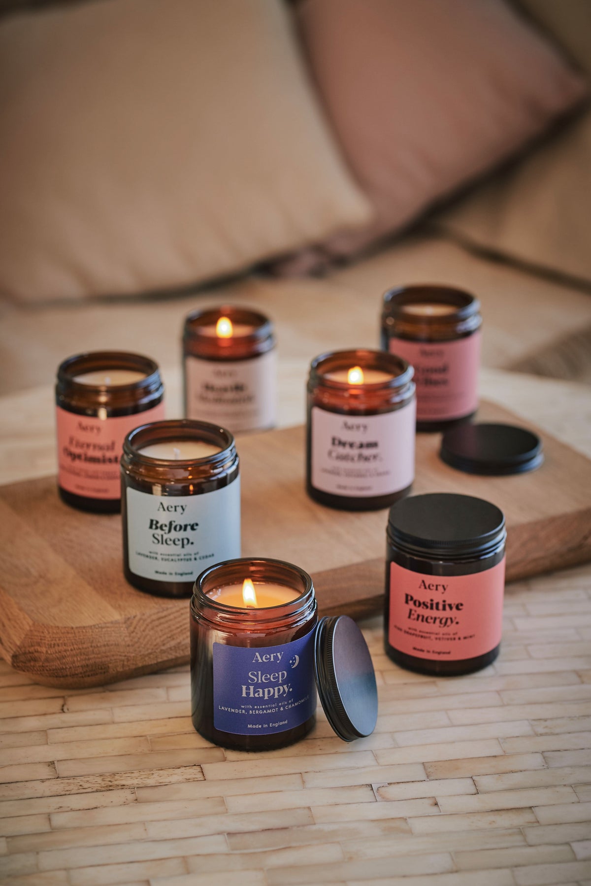 Collection of Aromatherapy jar candles by Aery displayed on wooden tray and and cream table