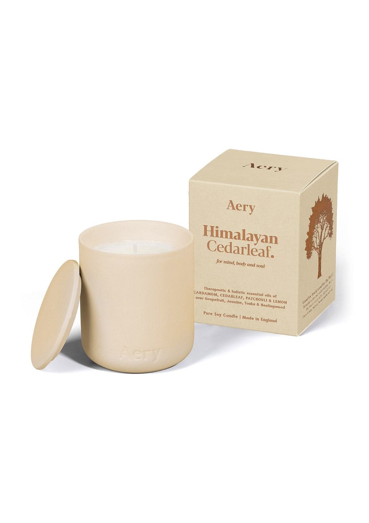 Cream Himalayan Cedarleaf ceramic scented candle displayed next to product packaging by Aery on white bacground