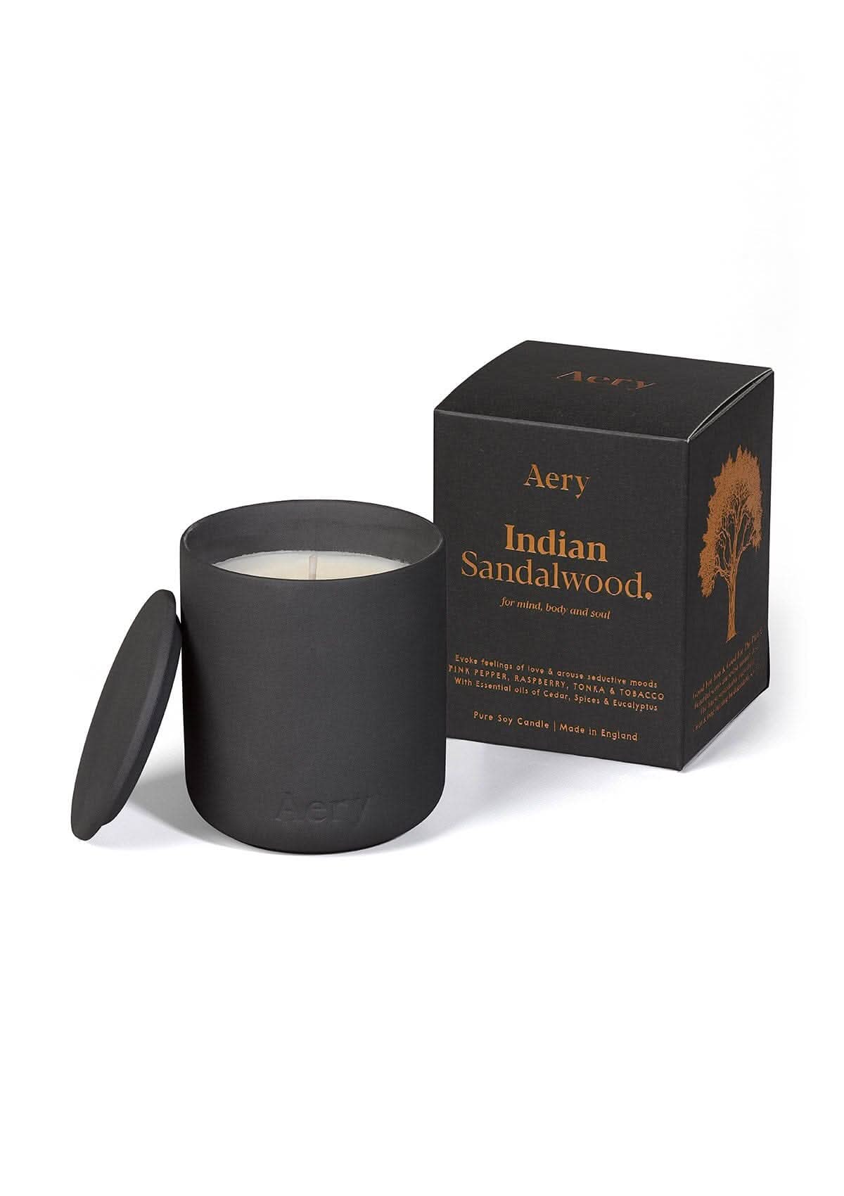 Black Indian Sandalwood ceramic scented candle displayed next to product packaging by Aery on white bacground