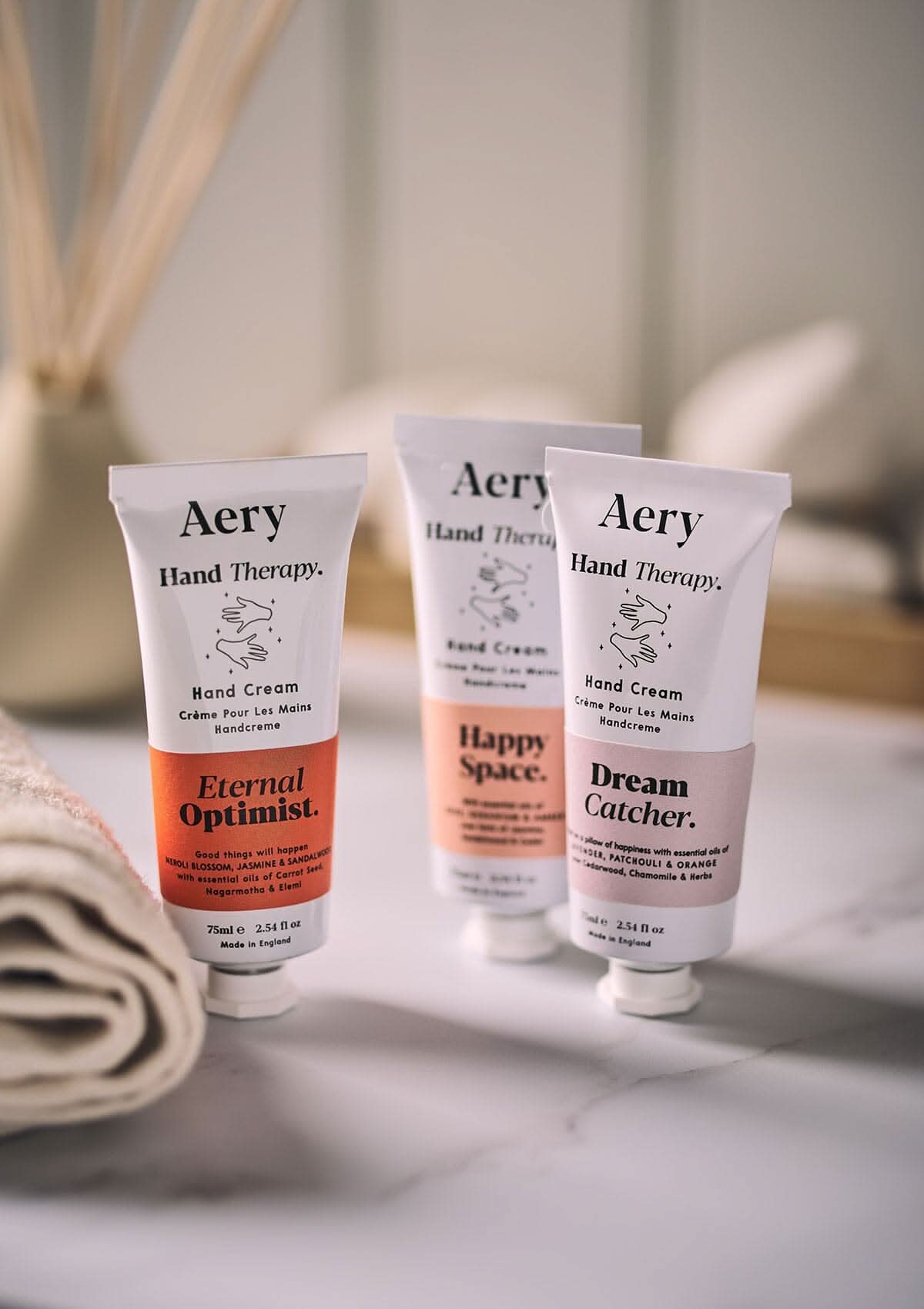 Pink Happy Space hand cream by Aery displayed next to Eternal Optimist and Dream Catcher hand cream in bathroom