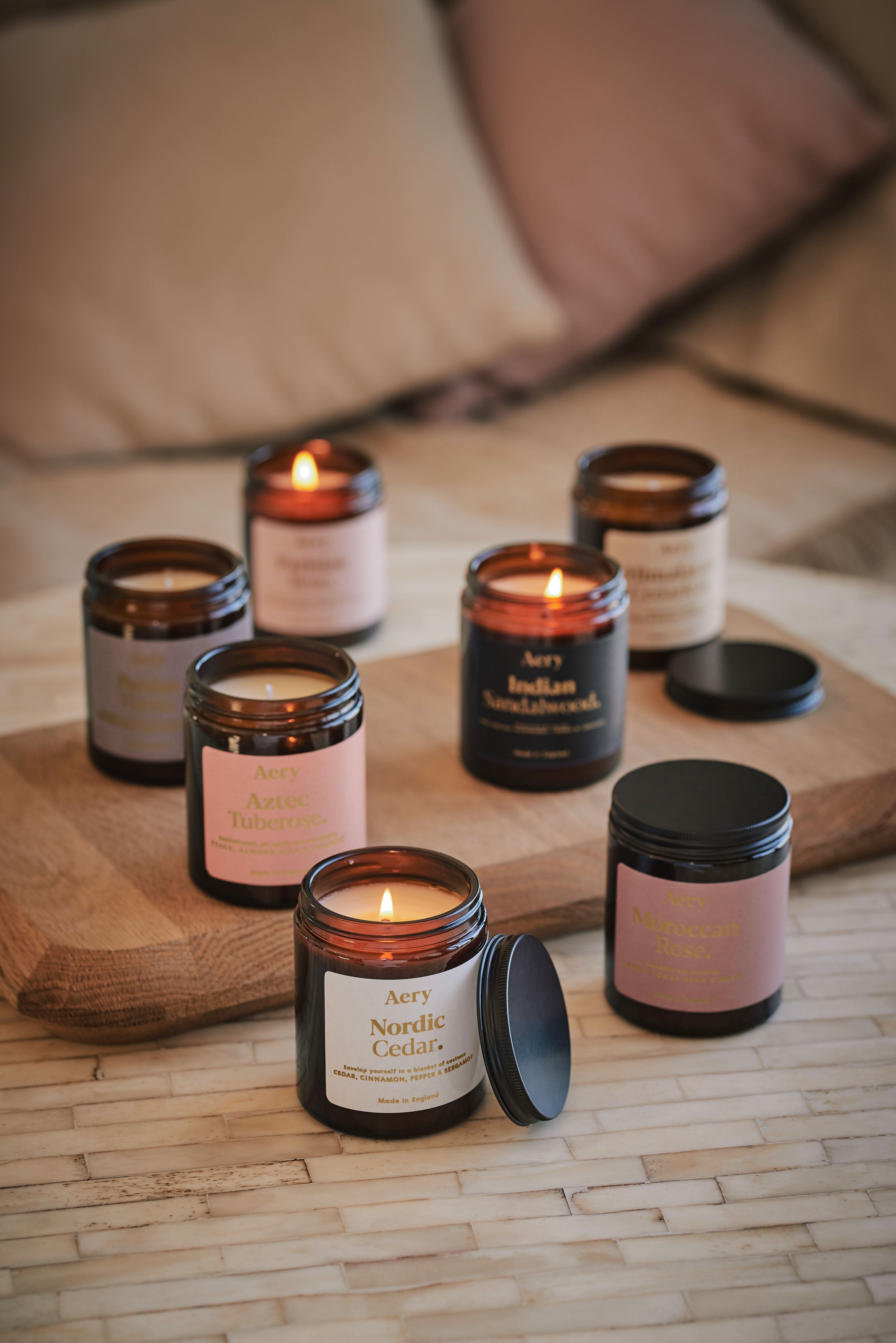 Collection of Fernweh jar candles by Aery displayed  on wooden tray and cream table