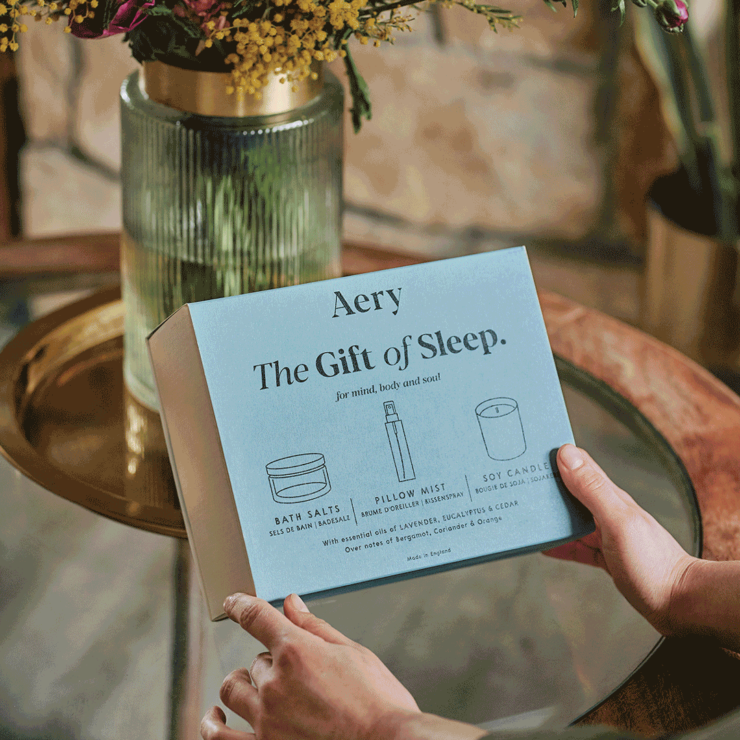 animation of person opening a before sleep gift set onto a coffee table and lighting the candle