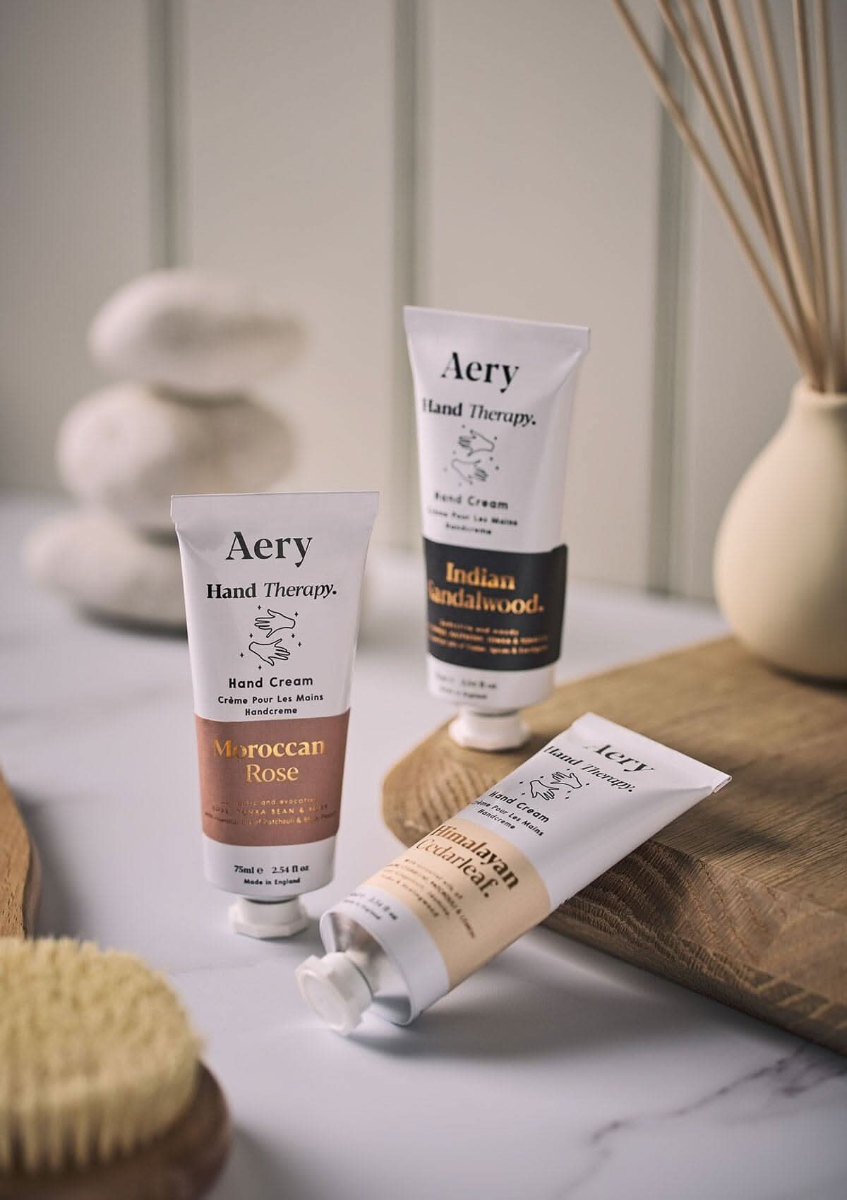 Black Indian Sandalwood hand cream  by Aery displayed next to Moroccan rose hand cream and Himalayan Cedarleaf hand cream placed in bathroom