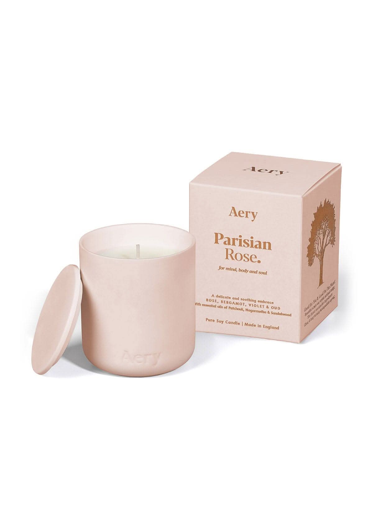 Pale pink ceramic Parisian Rose scented candle displayed next to product packaging by Aery on white bacground